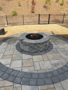A circular stone fire pit and a circular pation extending out around it
